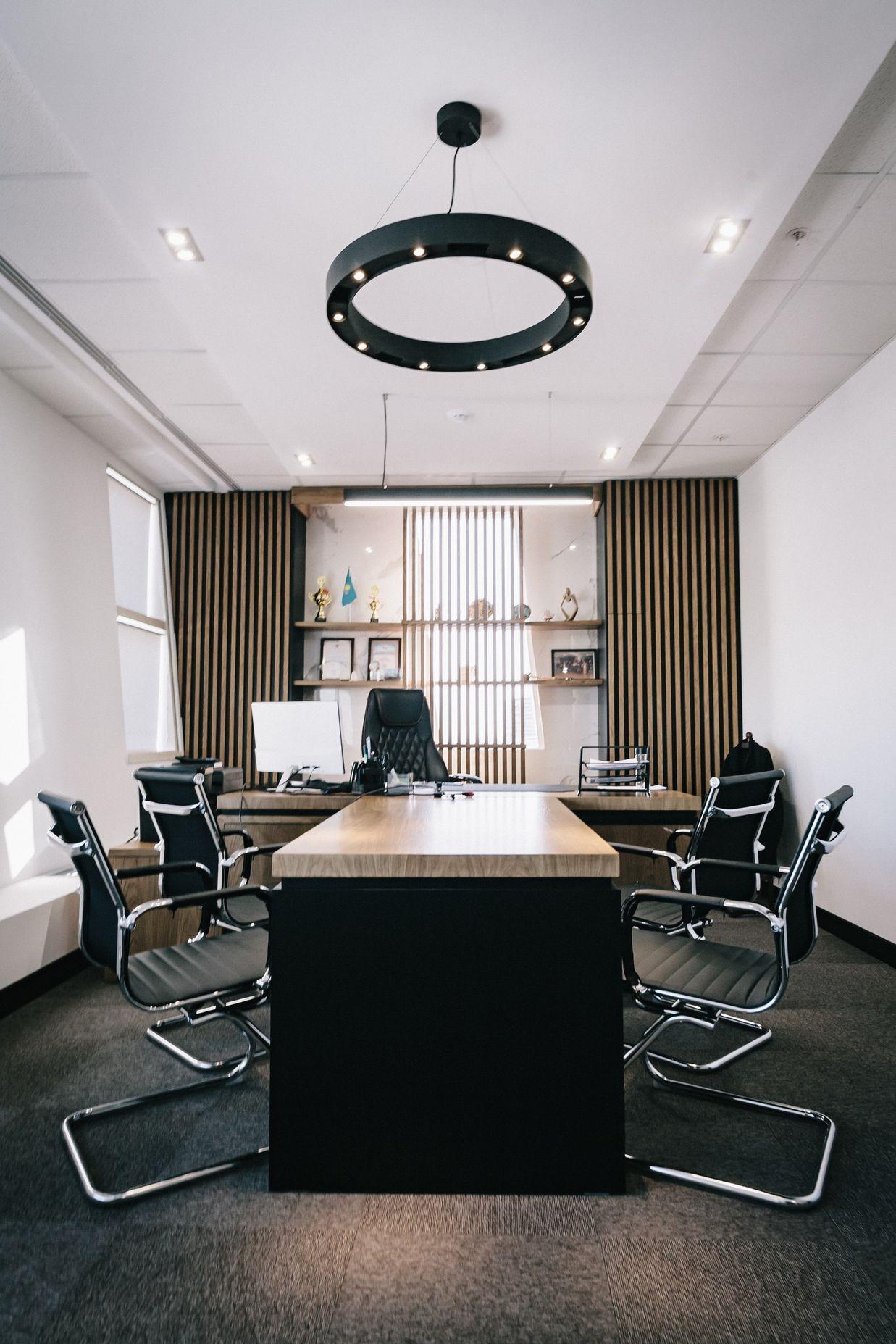 brown and black office table and four black cantilever chairs