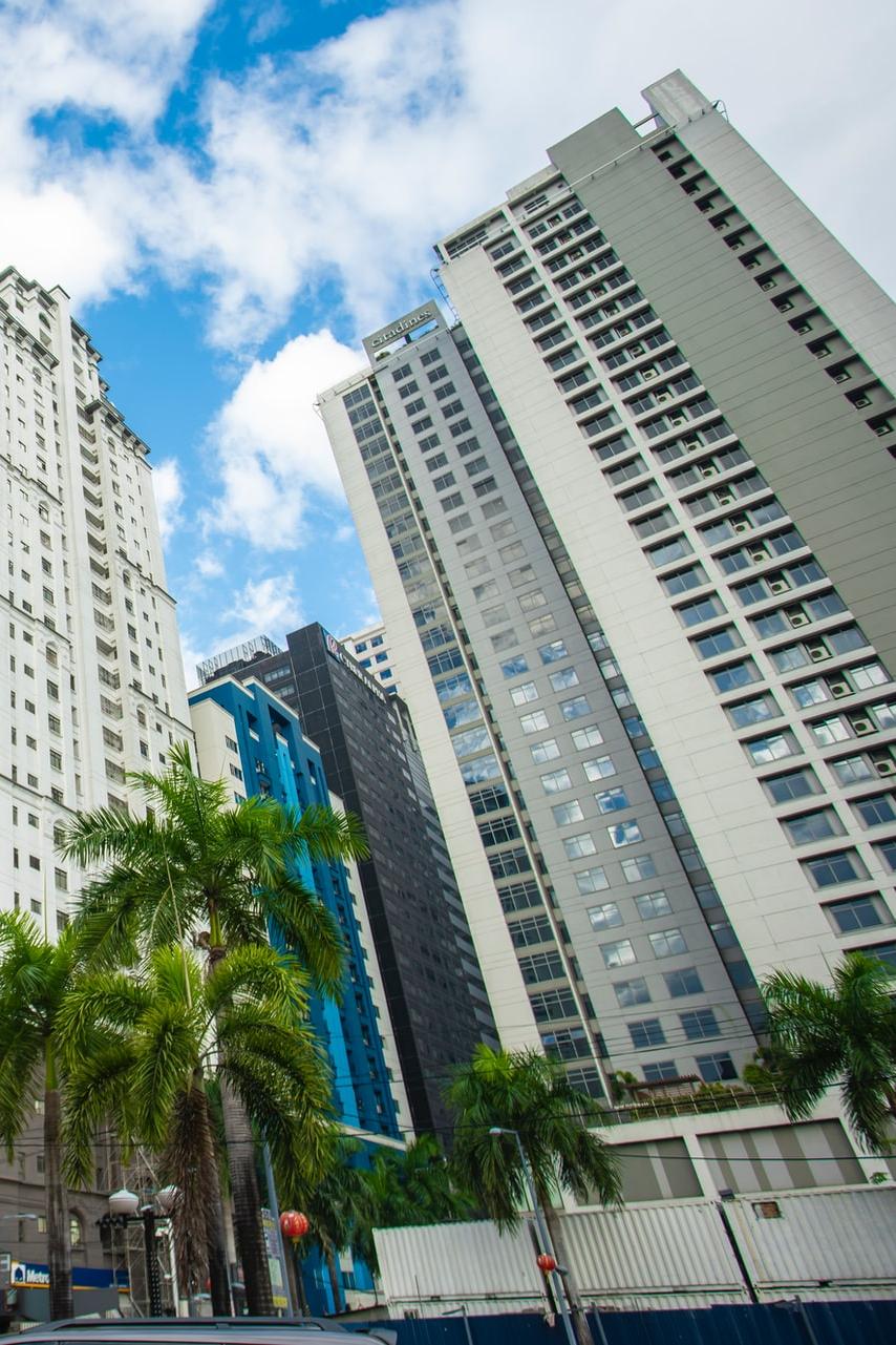 red and white concrete building under blue sky and white clouds during daytime